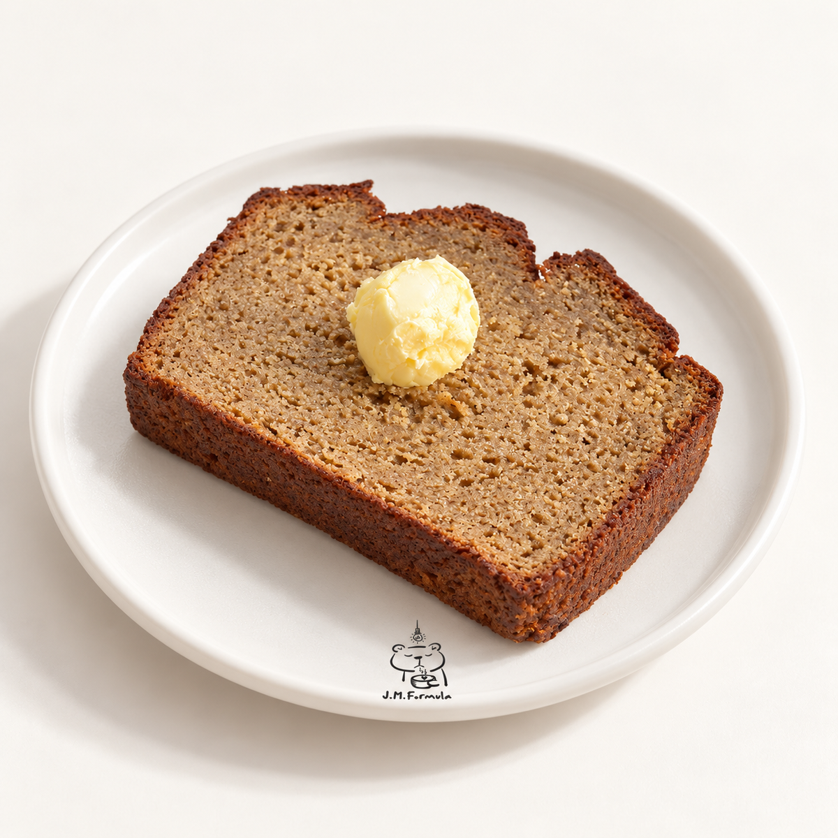 JM Formula Banana Bread with subtle JM Formula branding on an off-white background